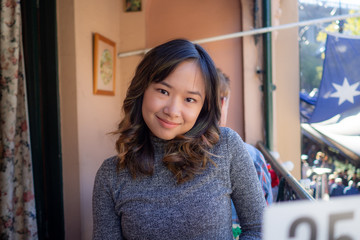 Young woman cheerfully sitting outside on a nice day