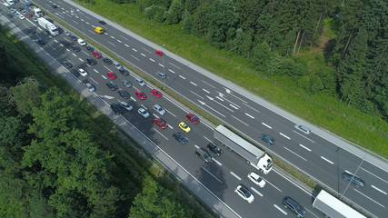 AERIAL: Countless cars and trucks moving through a bottleneck on the freeway.
