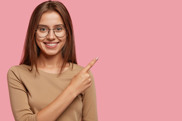 Photo of satisfied brunette Caucasian girl with tender smile, satisfied to take part in advertising...