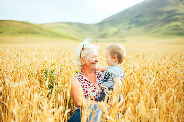 The grandmother holds the hand of a small boy on blur background. Concept of trust, support and help