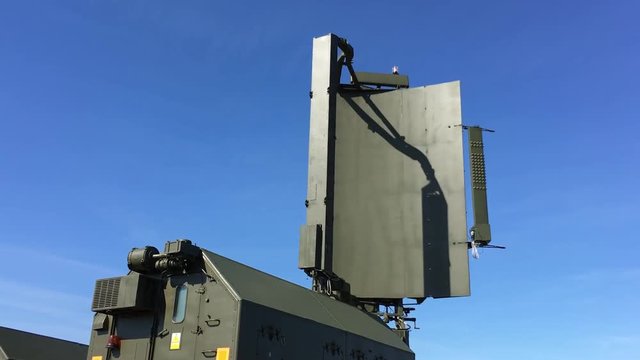 Green military radar is rotating - control, surveillance and monitoring of the clear blue air. High tech technology in the army.