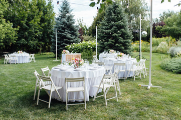 Wedding. Banquet. Chairs and honeymooners table decorated with candles,