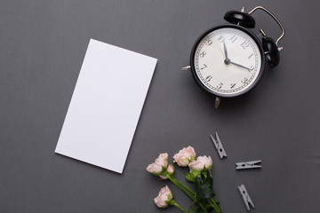 Empty white notepad with coffee and alarm clock on grey background in vintage style © KatrinaEra