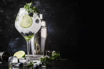 Foto op Plexiglas Zomer alcoholische cocktail bosbessen mojito met rum, groene munt, limoen en gemalen ijs, bar tools, grijze toog, selectieve focus © 5ph