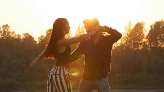 Concept of love and relationships Couple dancing bachata at sunset
