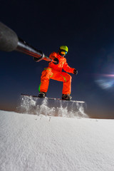 Snowboarder making a selfie by his action camera on the top of the ski slope
