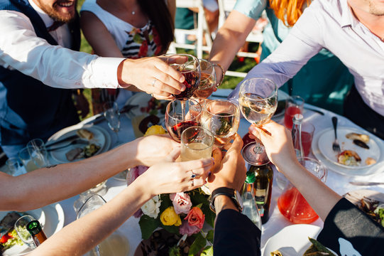 people at the table at a solemn event clink glasses and celebrate