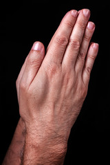 Male hands praying with palms together. Black background. Close up of man hand. Concept for prayer, pray, faith, religion, religious, worship