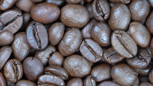 Fried coffee beans background, close up, rotation loopable 4k top view. Food  background. Gastronomy concept, organic food. Macro coffee beans