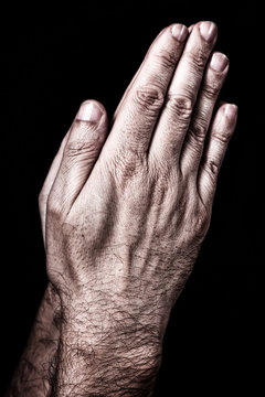 Male hands praying with palms together. Black background. Close up of man hand. Concept for prayer, pray, faith, religion, religious, worship