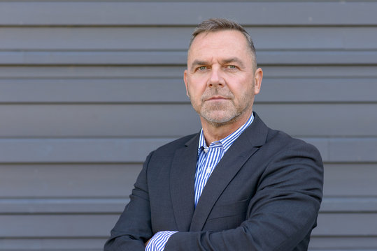 Confident middle age businessman over gray
