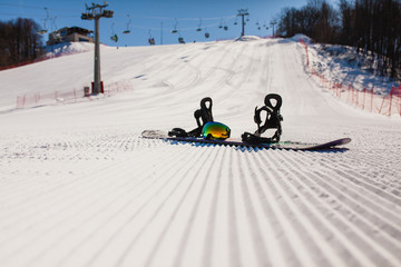 Bottom view on empty ski slope and equipment for snowboarding