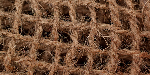 fabric made in the form of a rough coarse net of intertwined natural threads