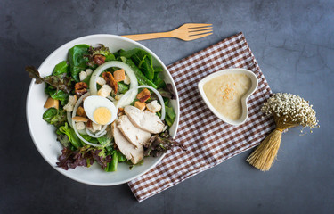 One big ceramic bowl of ceasar salad with ceasar dressing cream.