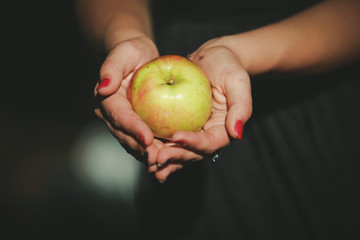 an apple in the hands of a young woman