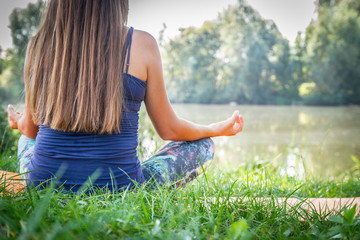 Young Caucasian woman in bodysuit relaxing by practicing yoga, gyan mudra and lotus position