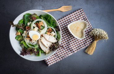 One big ceramic bowl of ceasar salad with ceasar dressing cream.