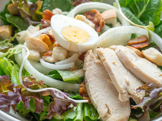 One big ceramic bowl of ceasar salad with ceasar dressing cream.