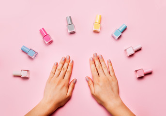Beautiful female hands with trendy stylish manicure on pink background.