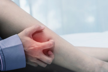 women lag pain on bed in bed room in the morning.