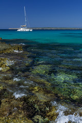 One sailboat and rocky coast