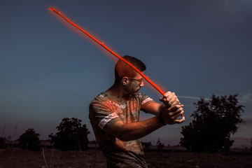 Fototapeta premium portrait of young man with glasses and beard playing with a stick