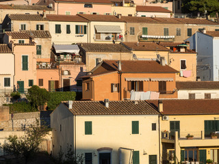 Geraffte Teleperspektive von bunten Wohnhäusern in der Abendsonne, Capoliveri, Elba