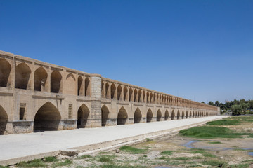 Fototapeta na wymiar Si o Seh Pol bridge on the afternoon in Isfahan, Iran. Also known as Allahverdi Khan Bridge, or 33 arches bridge, it is a major landmark of the city and a symbol of the Persian Safavid Architecture