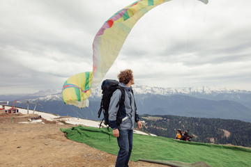 young handsome man is looking at people who are fond of base jumping. extreme sport, adventurouse...