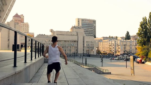 Running young man doing parkour tricks and somersaults. Gimbal shot. Stabilized footage.