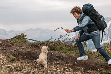 young peasant male tming his dog outdoors. side view shot.have fun