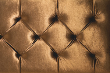 Beige soft textile background with symmetrical buttons on the corners of diamonds. Soft and...