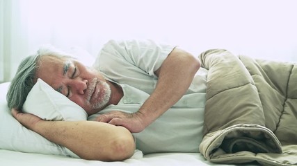 Senior man sleeping in bed. Old asian man sleeping comfortably in bed with curtain open. Senior lifesyle concept. Close up shot.