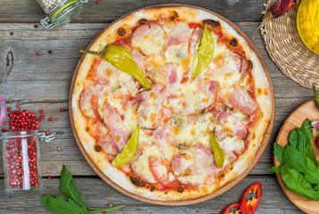 Pizza with tomatoes, mozzarella cheese, black olives and basil. Delicious italian pizza on wooden pizza board.
