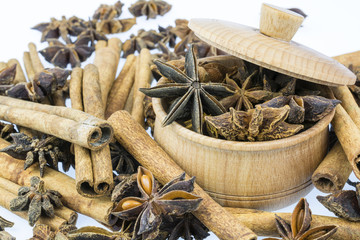 Sticks of cinnamon, an anise is star in a frug on a white background.