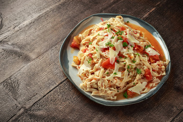 Homemade pasta in tomato sauce with parmesan cheese and parsley