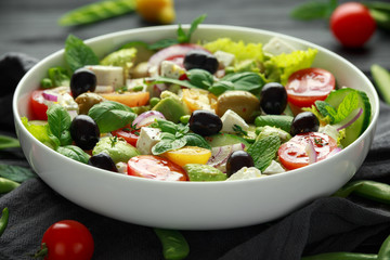 Healthy low calories salad with lettuce, heirloom tomatoes, avocado, feta cheese, red onion,...