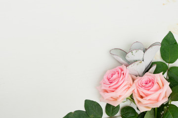 Rose fresh flowers with leaves on table from above with copy space, flat lay scene