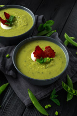 Sweet pea, leek and mint hot soup topped with crunchy bacon and dolop of yogurt