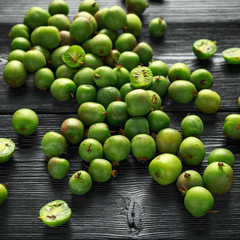 Fresh juicy Kiwi berries on black wooden background
