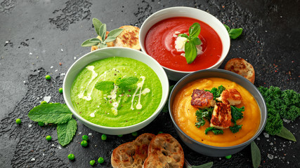 Variety of cream soup bowls: sweet pea and mint, tomato and basil and butternut squash with steamed...