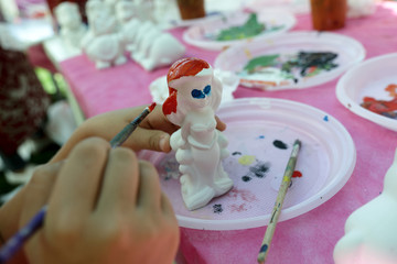 Person painting plaster figure