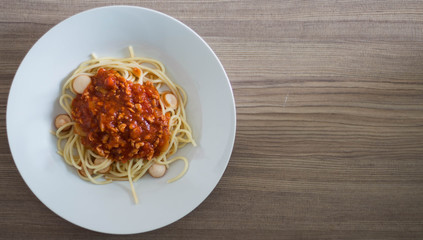 Spaghetti with Sausage Tomato Sauce on wood table.
