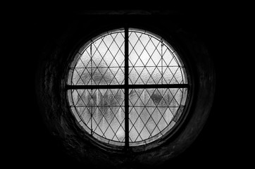 black and white photo of a round stained glass window in an old building