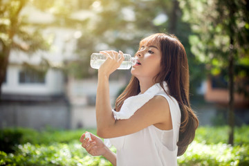 Asian young woman drinking water after workout exercising.