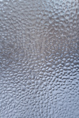 Frozen water drops on the winter window as background. 