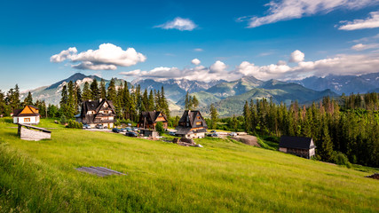 Obraz premium Few houses and wonderful Tatra mountains at sunset in summer