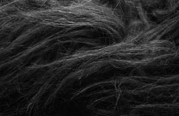 Black soft natural animal wool texture background. Skin wool. Close-up texture of dark fluffy fur. Gray plush