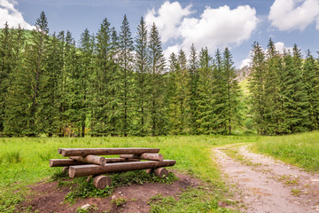 Naklejka premium Beautiful wooden bench in Koscieliska valley in Tatra Mountains
