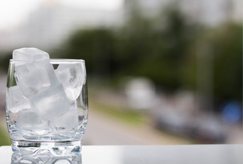 Glass of ice with natural background. Space for your text.